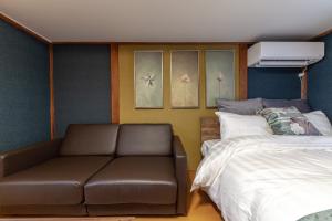 - une chambre avec un canapé à côté d'un lit dans l'établissement Ko-Fu-Sou, à Tokyo