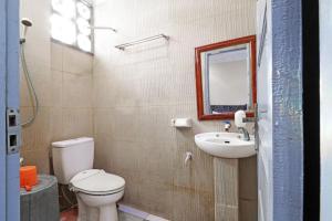 W łazience znajduje się toaleta, umywalka i lustro. w obiekcie Utama Syariah w mieście Pekanbaru