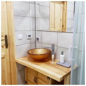 a bathroom with a wooden bowl sink on a wooden counter at Bieszczadzki Luz in Dwernik