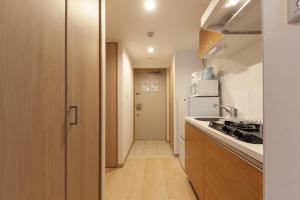 una pequeña cocina con fregadero y nevera. en ID Ohmori20, en Tokio