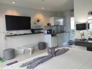 a living room with a bed with a towel on the floor at GrandBlue Condo 102 by malai in Mae Pim