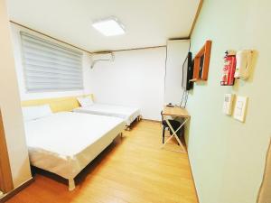 a room with two beds and a tv in it at Sarang Guesthouse Dongdaemun in Seoul