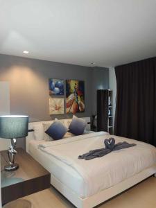 GrandBlue Condo 102 by malai في ماي بيم: غرفة نوم بسرير كبير عليها شريط