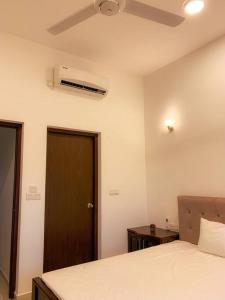 - une chambre avec un lit et un ventilateur de plafond dans l'établissement MaSa Beach Front Apartment Uswetakeiyawa, à Ja-Ela