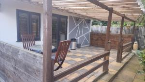 a patio with a pergola and a table and chairs at Rear of Levett Gardens in Seven Kings