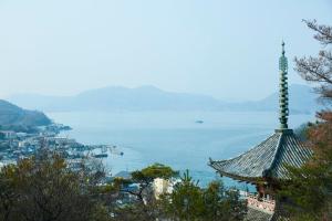 een pagode op een heuvel naast een waterlichaam bij yubune in Onomichi