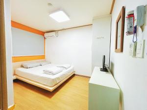 a small room with a bed and a tv in it at Sarang Guesthouse Dongdaemun in Seoul