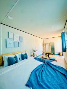 a bedroom with a large bed with blue pillows at Suly's Village Phan Thiết in Phan Thiet
