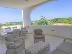 a balcony with chairs and a table and a view of the ocean at Villa Adele in Torre Santa Sabina