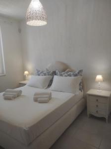a bedroom with a white bed with two towels on it at Villa Adele in Torre Santa Sabina