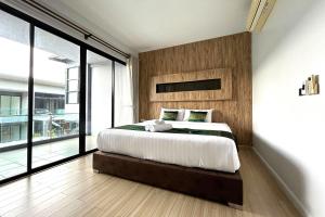a bedroom with a large bed and a large window at Nice Villa Resort in Songkhla