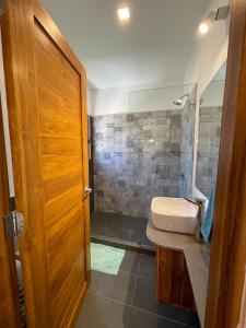 a bathroom with a shower and a sink and a door at Green Turtle Townhome #1 Private Pool & Garden 300 Mtrs to Beach in Tamarindo +13 photos