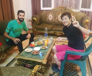 開羅的住宿－Andy Guest House，坐在客厅的两个人,桌上摆着食物