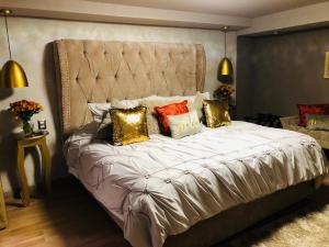 een slaapkamer met een groot bed met gouden kussens bij Casa Neek in San Cristóbal de Las Casas