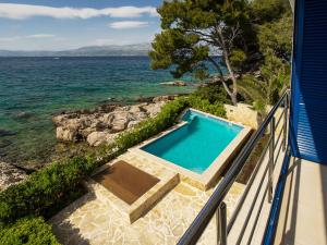 a swimming pool on a balcony overlooking the ocean at Villas Violet & Rosemary in Supetar