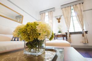 a vase of flowers on a table in a room at Classic Victorian Presidential Suite West Nanjing Rd in Shanghai