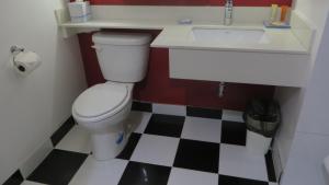 ein Badezimmer mit einem WC und einem Waschbecken sowie einem karierten Boden in der Unterkunft Legend Hotel Hollywood in Los Angeles + 15 Fotos