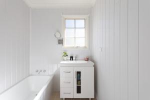 a white bathroom with a sink and a bath tub at Nilgiri 3BR Mountain Retreat 5mins Katoomba Centre in Katoomba +13 photos