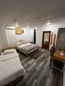 a bedroom with two beds and a desk and a mirror at Pensiunea Old Sheriff in Bistriţa