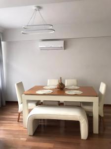 a dining room table with white chairs and a light fixture at Cozy and Modern Flat Near Bosphorus At Arnavutköy in Istanbul