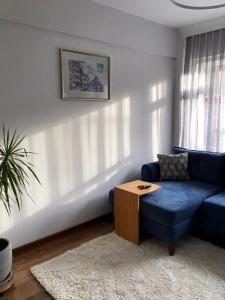 a living room with a blue couch and a table at Cozy and Modern Flat Near Bosphorus At Arnavutköy in Istanbul