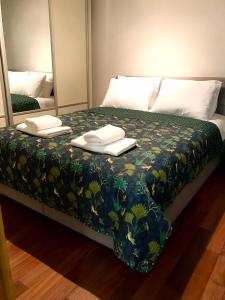 Una cama con dos toallas y dos espejos. en Cozy and Modern Flat Near Bosphorus At Arnavutköy, en Estambul
