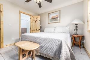 1 dormitorio con cama, mesa y ventana en The Lodge at Duck Creek en Duck Creek Village
