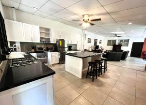 a large kitchen with white cabinets and black counter tops at San Diego Beach House, near La Lib and Surf City in La Libertad