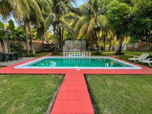 uma piscina num quintal com um piso vermelho e árvores em San Diego Beach House, near La Lib and Surf City em La Libertad