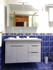 baño con lavabo blanco y azulejos azules en Cozy and Modern Flat Near Bosphorus At Arnavutköy, en Estambul