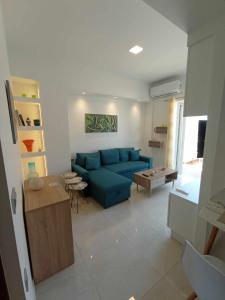 un soggiorno con divano blu e tavolo di Ethereum City Αpartment - Suite a Chania