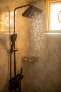 a shower with a shower head in a bathroom at Palm Cultural Village in Paje