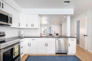 una cucina con armadietti bianchi e lavastoviglie in acciaio inossidabile di 2 Bedroom East Riverside Home with Garage-Sleeps 6 ad Austin