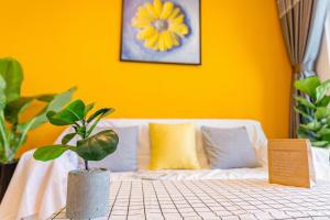 une pièce jaune avec un canapé et une plante en pot dans l'établissement Căn Hộ Vũng Tàu View Biển - Vũng Tàu Apartments Sea View, à Vung Tau 84 autres photos