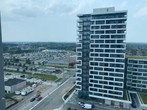 a tall building in a city with a highway at QQ MARKHAM condo in Markham