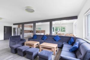uma sala de estar com um sofá azul e cadeiras azuis em Holiday House Adam em Prosečné