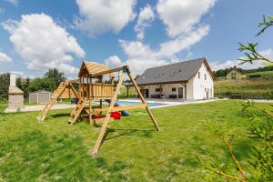 a playground in a yard with a house at Holiday House Adam in Prosečné
