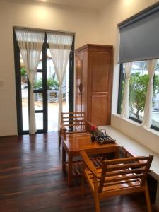 uma sala de jantar com 2 cadeiras e uma mesa de madeira em Lightly Homestay em Ho Coc