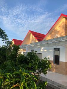 a white house with a red roof at Lightly Homestay in Ho Coc