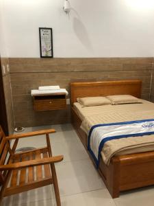 ein Schlafzimmer mit einem Bett, einem Stuhl und einem Tisch in der Unterkunft Lightly Homestay in Ho Coc