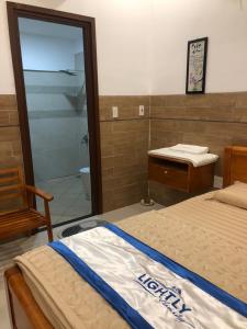 ein Schlafzimmer mit einem Bett und ein Bad mit einer Dusche in der Unterkunft Lightly Homestay in Ho Coc