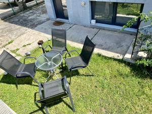 eine Gruppe Stühle und ein Tisch im Gras in der Unterkunft Deluxe Apartment #CasaMihai Free Parking in Braşov