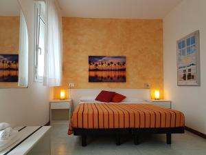una camera con un letto con due tavoli e due lampade di Hotel Nuova Graziosa a Lignano Sabbiadoro