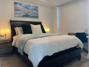 a bedroom with a large bed and two lamps at QQ MARKHAM condo in Markham