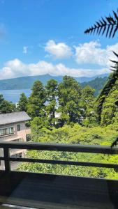 a balcony with a view of the mountains and trees at 森の中富士山見える部屋202 in Hakone
