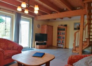 ein Wohnzimmer mit einem Tisch und einem TV in der Unterkunft Dat Osterhuus in Neßmersiel