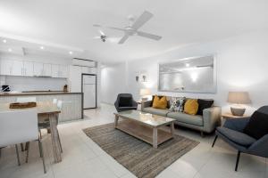 Fairshore Apartment 12, Noosa Heads في نوسا هيدز: غرفة معيشة مع أريكة وطاولة