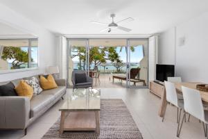 a living room with a couch and a table at Fairshore 12: Absolute Beachfront, Direct Beach & Pool Access in Noosa Heads