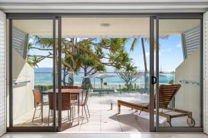 un patio con tavolo, sedie e vista sull'oceano di Fairshore Apartment 12, Noosa Heads a Noosa Heads