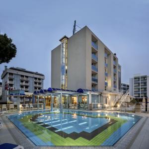 um hotel com piscina em frente a um edifício em Hotel San Michele em Bibione